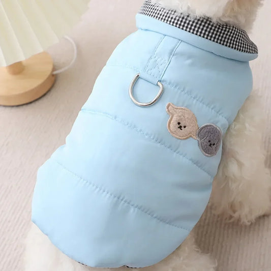 Light blue dog coat with bear patches on a soft surface